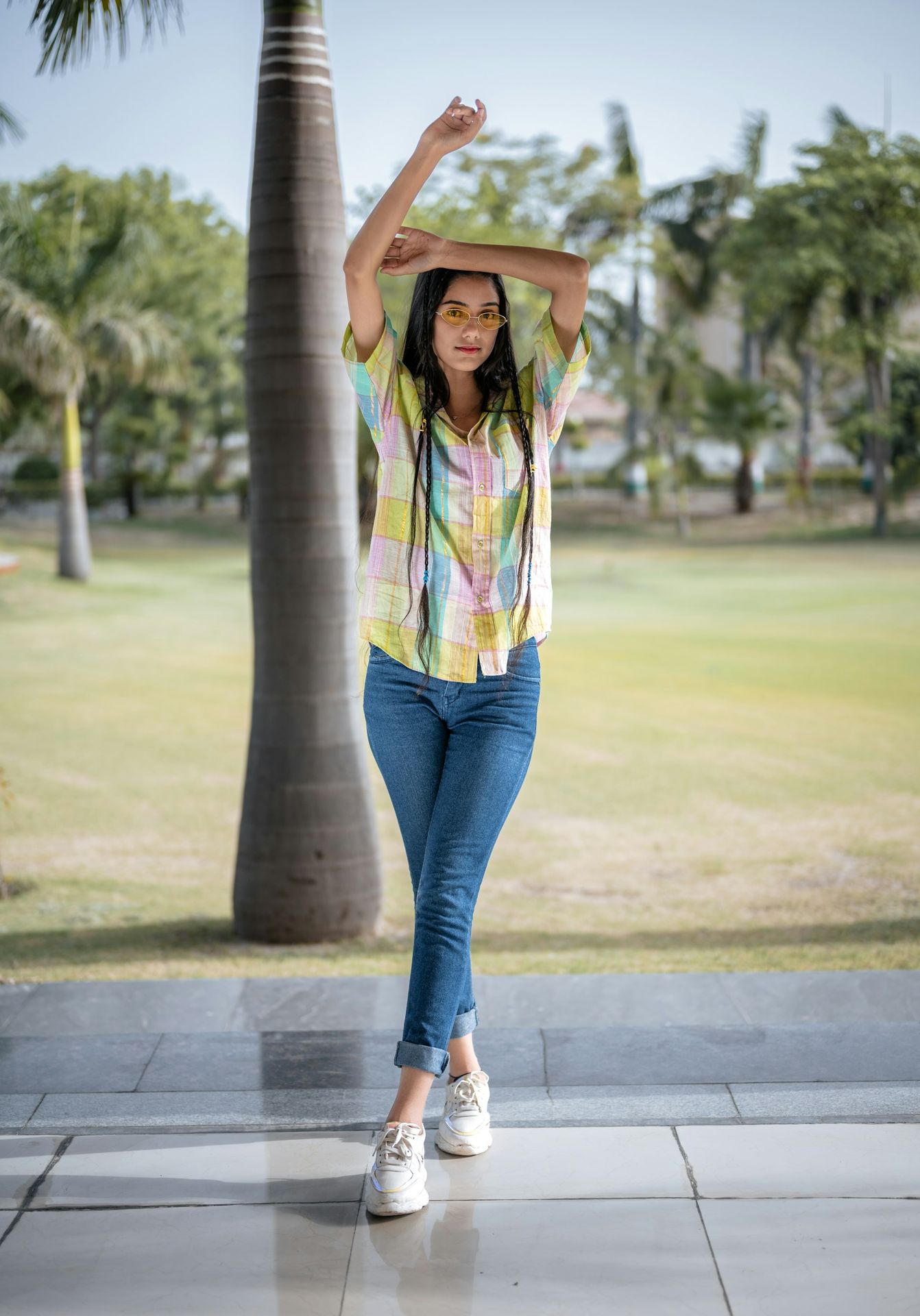 A woman standing in front of a palm tree